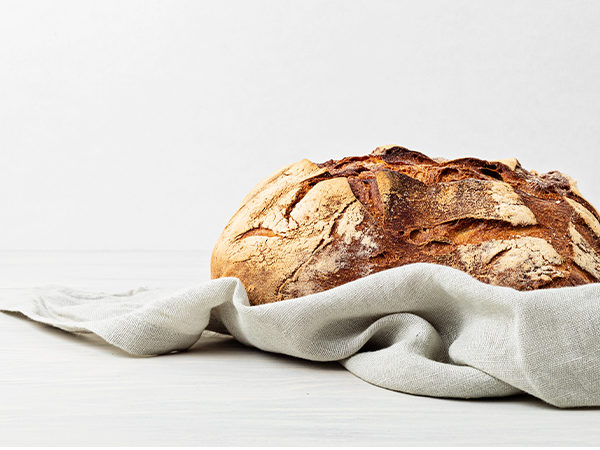 Brot auf weißem Hintergrund in Tuch gehüllt
